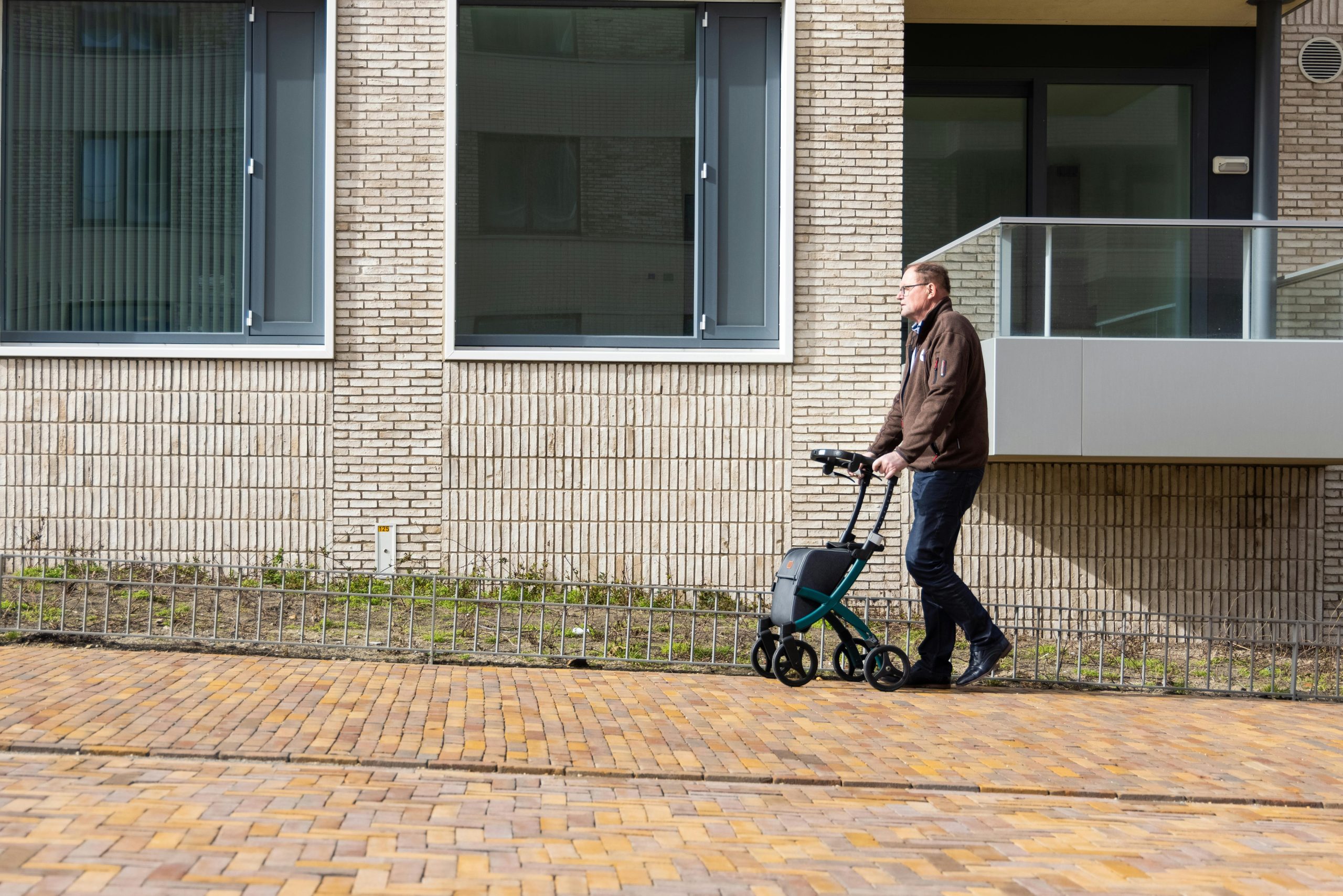 A person is using a Rollator walker to go uphill